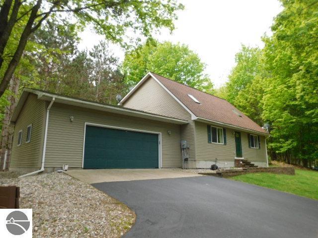 12149 Cabin Ln, Rapid City, MI 49676 - single story home featuring a garage and asphalt driveway