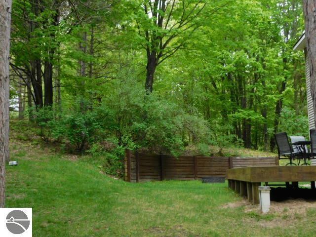 12149 Cabin Ln, Rapid City, MI 49676 - view of grassy yard featuring a view of trees