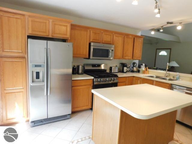 12149 Cabin Ln, Rapid City, MI 49676 - kitchen featuring appliances with stainless steel finishes, light countertops, a sink, and light tile patterned floors