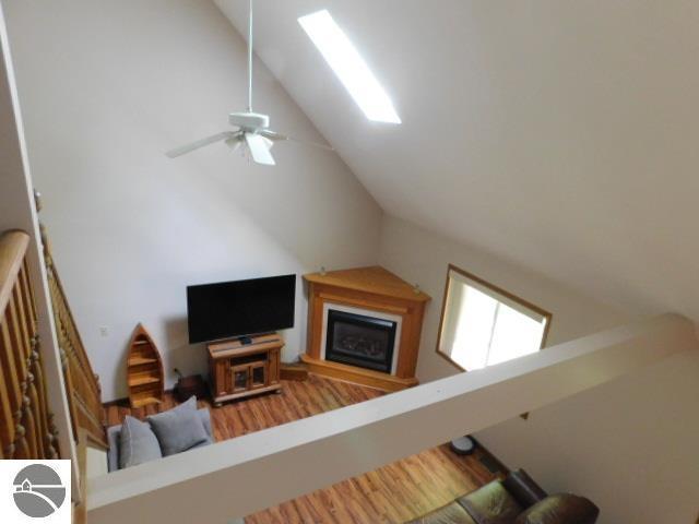12149 Cabin Ln, Rapid City, MI 49676 - living room featuring vaulted ceiling, wood finished floors, and a ceiling fan