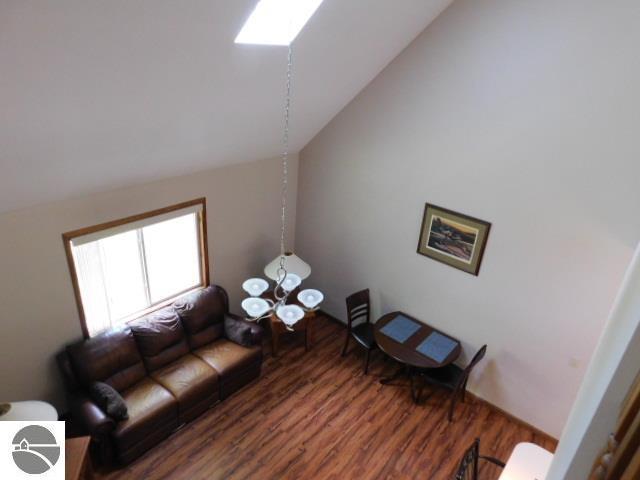 12149 Cabin Ln, Rapid City, MI 49676 - living area featuring lofted ceiling and wood finished floors