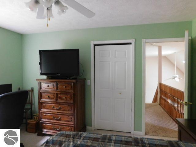 12149 Cabin Ln, Rapid City, MI 49676 - bedroom featuring carpet flooring and ceiling fan