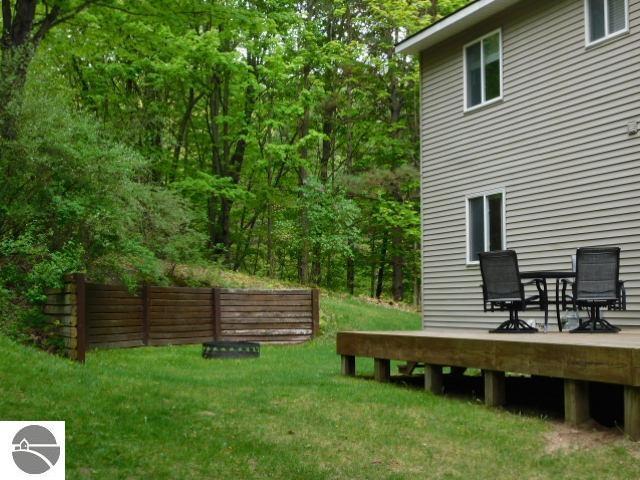 12149 Cabin Ln, Rapid City, MI 49676 - view of green lawn with a wooden deck