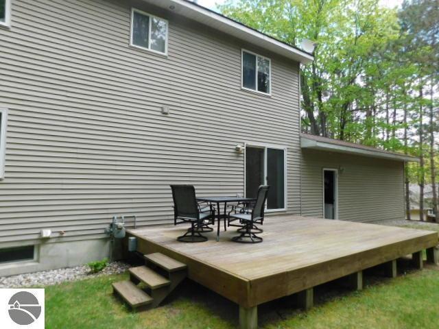 12149 Cabin Ln, Rapid City, MI 49676 - back of house featuring a wooden deck and outdoor dining area