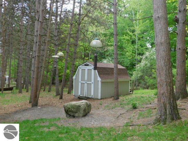 12149 Cabin Ln, Rapid City, MI 49676 - view of shed with a view of trees
