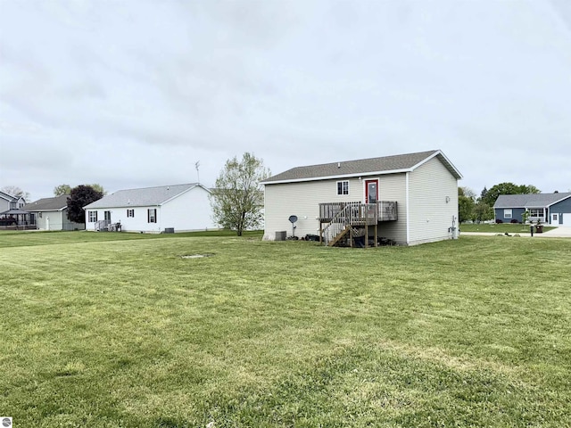 2442 Joseph Dr, Mount Pleasant, MI 48858 - back of property with stairway, a lawn, and a wooden deck