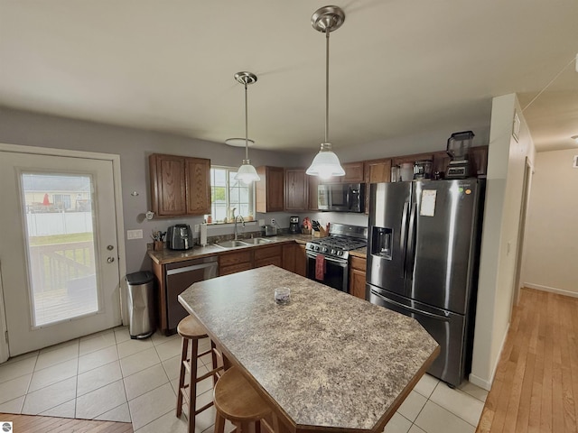 2442 Joseph Dr, Mount Pleasant, MI 48858 - kitchen featuring appliances with stainless steel finishes, a sink, pendant lighting, a center island, and light tile patterned floors