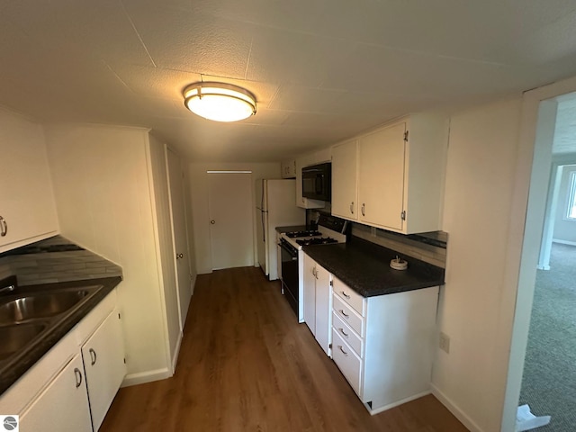 1007 Park St, Mount Pleasant, MI 48858 - kitchen with range with gas stovetop, black microwave, dark countertops, white cabinets, and dark wood-style floors