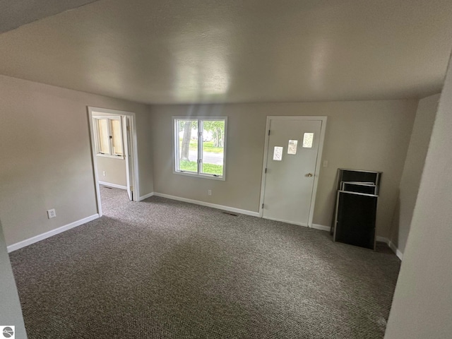 1007 Park St, Mount Pleasant, MI 48858 - unfurnished living room with dark colored carpet and baseboards