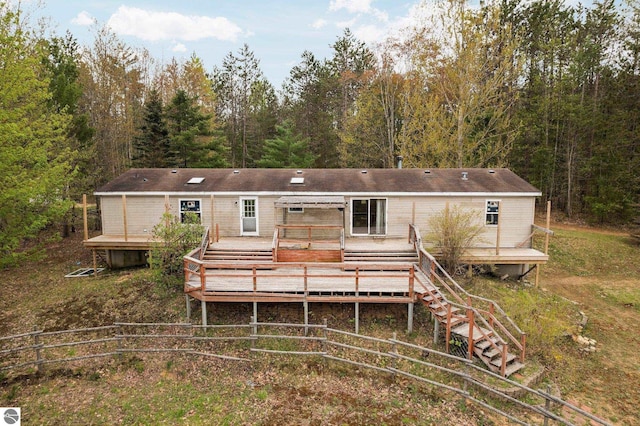 11567 Lake Valley Rd, Kalkaska, MI 49646 - back of house featuring a deck and a forest view