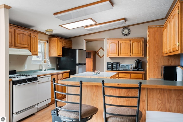 11567 Lake Valley Rd, Kalkaska, MI 49646 - kitchen featuring white appliances, under cabinet range hood, a sink, vaulted ceiling, and light wood-type flooring