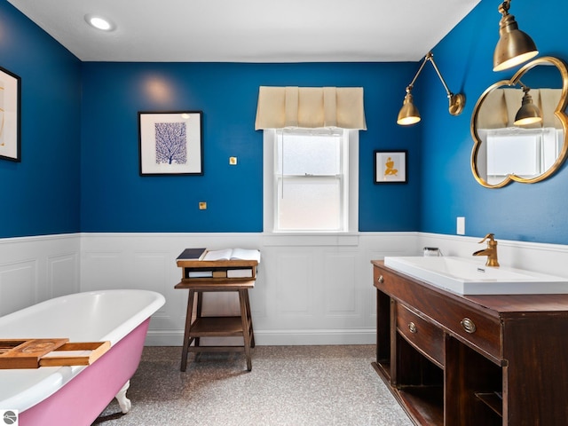 855 E State St, Traverse City, MI 49686 - full bathroom featuring a freestanding bath, a wainscoted wall, vanity, and a decorative wall