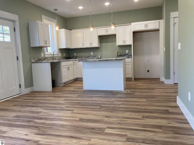 9286 S Flaska Dr Unit 12, Cedar, MI 49621 - kitchen with a center island, healthy amount of natural light, white cabinetry, recessed lighting, and baseboards