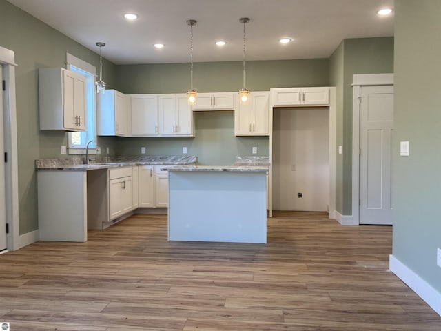 9296 S Flaska Dr Unit 14, Cedar, MI 49621 - kitchen featuring a center island, baseboards, recessed lighting, wood finished floors, and white cabinets