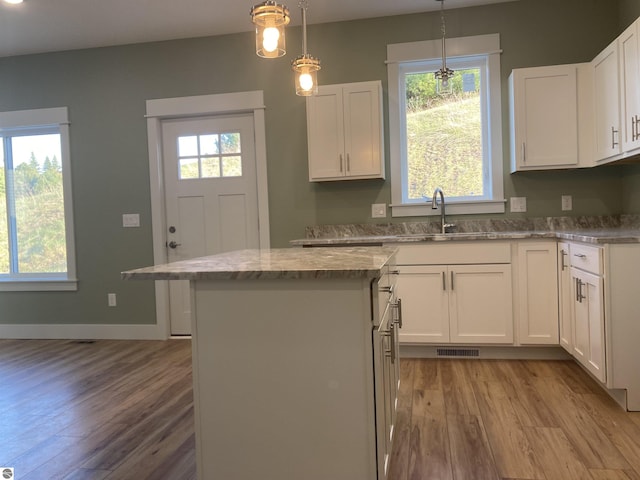 9296 S Flaska Dr Unit 14, Cedar, MI 49621 - kitchen featuring light wood-type flooring, a sink, a kitchen island, and white cabinetry