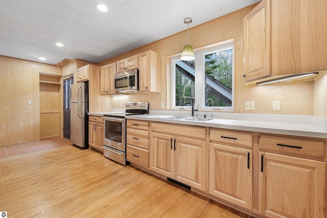 145 Fisher Rd, Traverse City, MI 49685 - kitchen with stainless steel appliances, light brown cabinetry, a sink, light wood finished floors, and light countertops