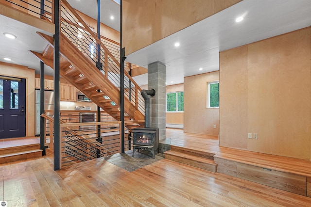 145 Fisher Rd, Traverse City, MI 49685 - stairs with hardwood / wood-style floors, a baseboard heating unit, a wood stove, and recessed lighting