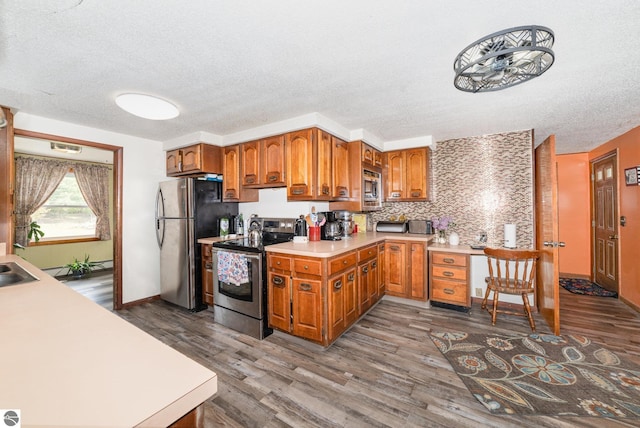 6770 N Crystal, Vestaburg, MI 48891 - kitchen featuring appliances with stainless steel finishes, brown cabinets, light countertops, a textured ceiling, and dark wood-style floors