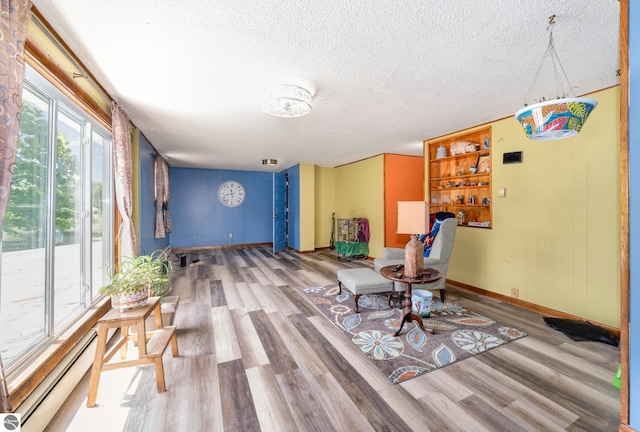 6770 N Crystal, Vestaburg, MI 48891 - unfurnished dining area featuring a baseboard radiator, baseboards, wood finished floors, and a textured ceiling