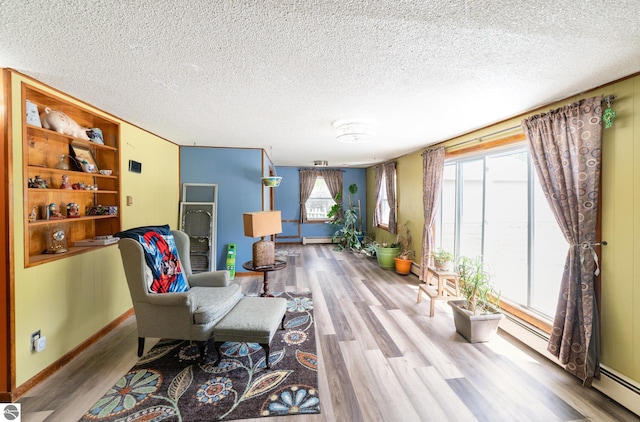 6770 N Crystal, Vestaburg, MI 48891 - sitting room featuring wood finished floors, a textured ceiling, baseboards, and a baseboard radiator