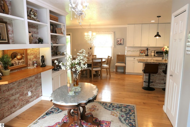 505 Eaton St, Breckenridge, MI 48615 - dining area with a chandelier, light wood-style flooring, baseboards, and ornamental molding