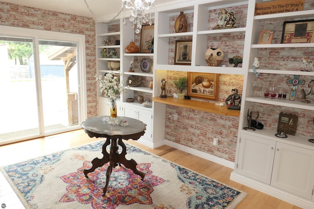 505 Eaton St, Breckenridge, MI 48615 - living area featuring light wood-style floors, a chandelier, wallpapered walls, and baseboards