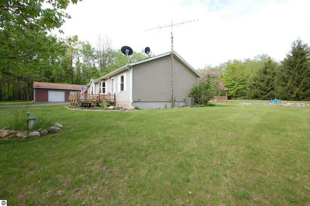 1137 Stoney Ridge Rd, West Branch, MI 48661 - view of side of property with an outdoor structure, a yard, a garage, and a deck