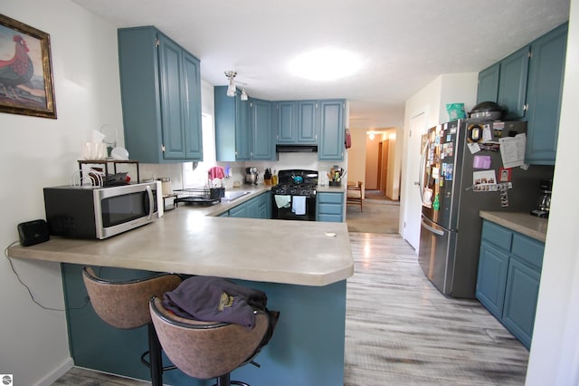 1137 Stoney Ridge Rd, West Branch, MI 48661 - kitchen featuring stainless steel appliances, blue cabinets, and light wood finished floors