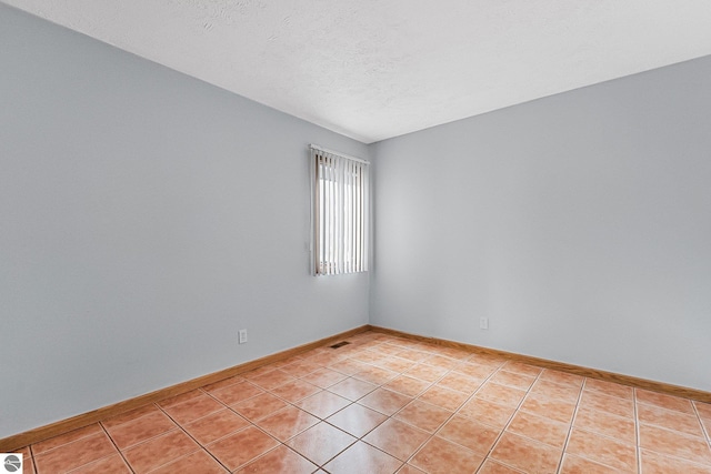 2683 Green Meadows Dr Unit 10, Traverse City, MI 49685 - unfurnished room featuring light tile patterned floors, baseboards, and a textured ceiling