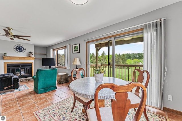 2683 Green Meadows Dr Unit 10, Traverse City, MI 49685 - dining space featuring light tile patterned flooring, ceiling fan, and a fireplace