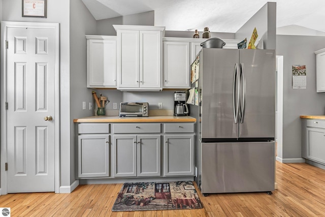 4667 Arbor Latch, Traverse City, MI 49685 - kitchen featuring freestanding refrigerator, gray cabinets, lofted ceiling, light wood-type flooring, and baseboards