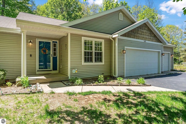 4667 Arbor Latch, Traverse City, MI 49685 - view of front of house featuring an attached garage, driveway, and a porch
