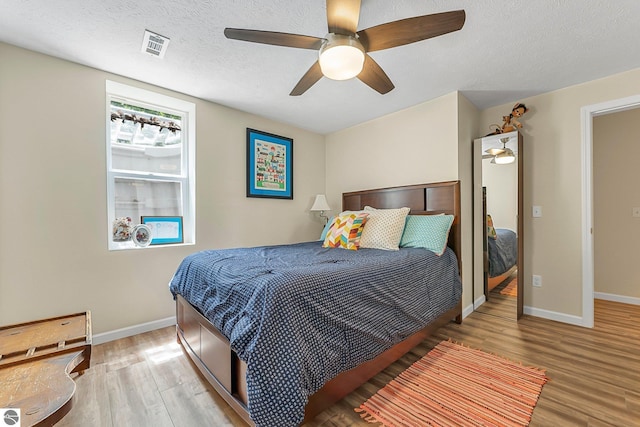 4667 Arbor Latch, Traverse City, MI 49685 - bedroom with wood finished floors, baseboards, a textured ceiling, and a ceiling fan