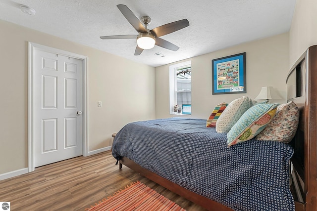 4667 Arbor Latch, Traverse City, MI 49685 - bedroom featuring wood finished floors, baseboards, a ceiling fan, and a textured ceiling