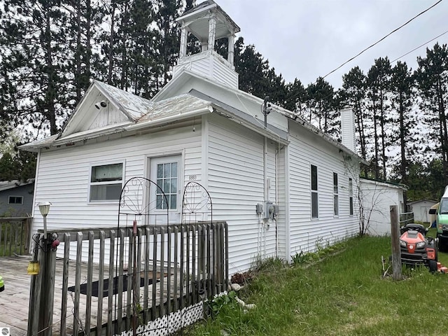 6993 E 34th Rd, Cadillac, MI 49601 - view of property exterior featuring a chimney and a wooden deck