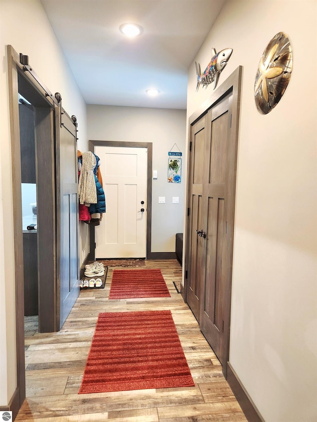 6238 E Gallivan Rd, Cedar, MI 49621 - foyer entrance featuring a barn door, wood finished floors, baseboards, and recessed lighting