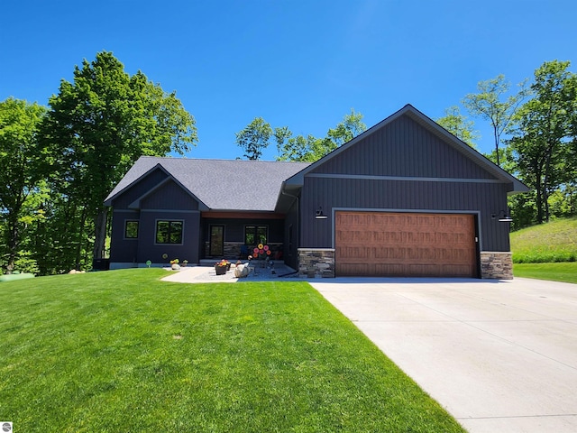 6238 E Gallivan Rd, Cedar, MI 49621 - view of front of property with stone siding, driveway, a front lawn, and an attached garage