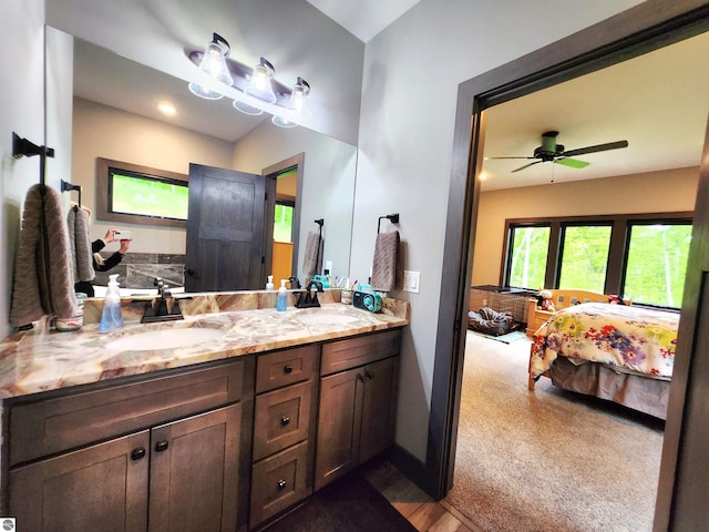 6238 E Gallivan Rd, Cedar, MI 49621 - ensuite bathroom featuring double vanity, a ceiling fan, and baseboards