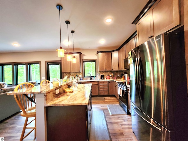 6238 E Gallivan Rd, Cedar, MI 49621 - kitchen with stainless steel appliances, a breakfast bar, light wood finished floors, tasteful backsplash, and recessed lighting