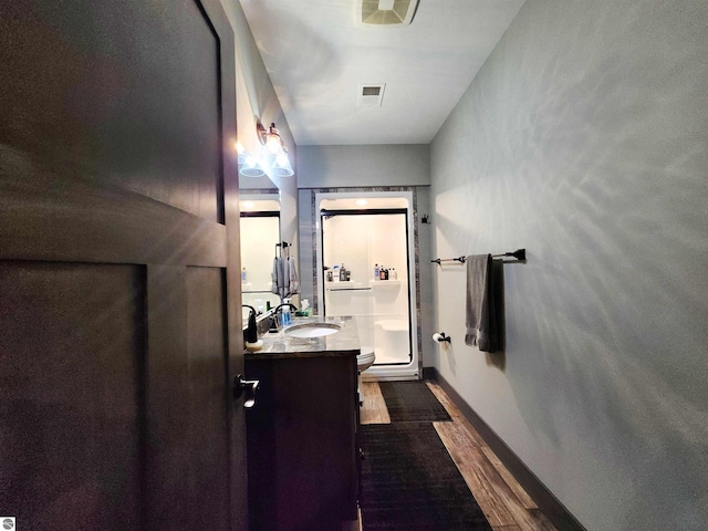 6238 E Gallivan Rd, Cedar, MI 49621 - full bathroom with vanity, wood finished floors, baseboards, and toilet