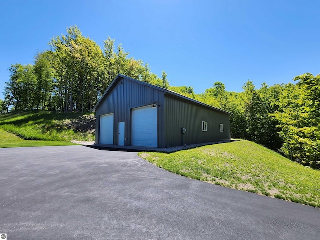 6238 E Gallivan Rd, Cedar, MI 49621 - view of property exterior with a detached garage, an outbuilding, and a lawn