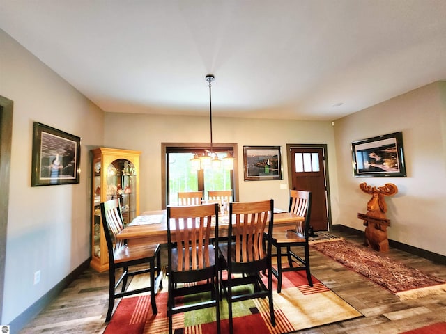 6238 E Gallivan Rd, Cedar, MI 49621 - dining space featuring wood finished floors, a chandelier, and baseboards