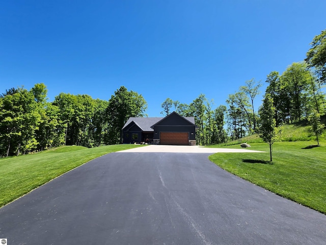 6238 E Gallivan Rd, Cedar, MI 49621 - view of front facade featuring an attached garage, asphalt driveway, stone siding, and a front yard