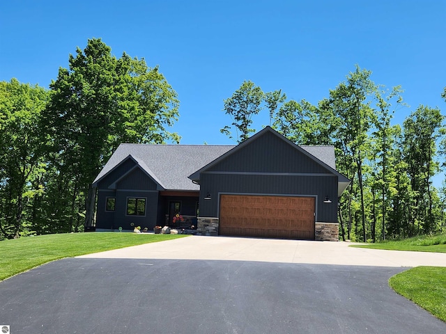 6238 E Gallivan Rd, Cedar, MI 49621 - view of front facade featuring driveway, an attached garage, stone siding, and a front lawn
