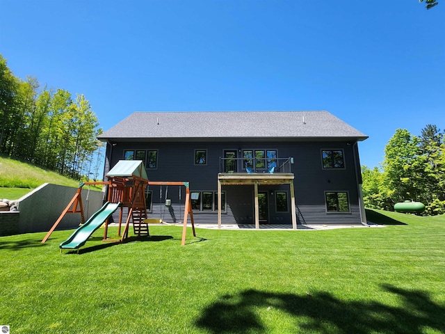 6238 E Gallivan Rd, Cedar, MI 49621 - back of property with a balcony, a playground, a lawn, and a patio area