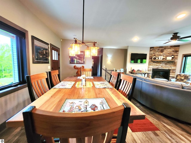 6238 E Gallivan Rd, Cedar, MI 49621 - dining room with wood finished floors, a stone fireplace, ceiling fan, recessed lighting, and a chandelier