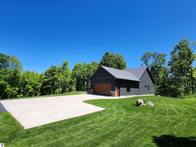 6238 E Gallivan Rd, Cedar, MI 49621 - view of green lawn featuring concrete driveway and a garage