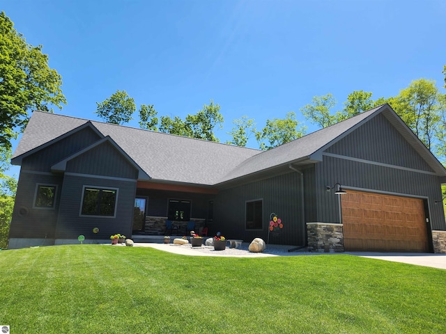 6238 E Gallivan Rd, Cedar, MI 49621 - rear view of property featuring stone siding, a shingled roof, a yard, a garage, and board and batten siding