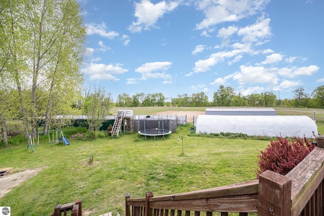 10745 W Remick Rd, Blanchard, MI 49310 - view of grassy yard featuring a trampoline and a playground