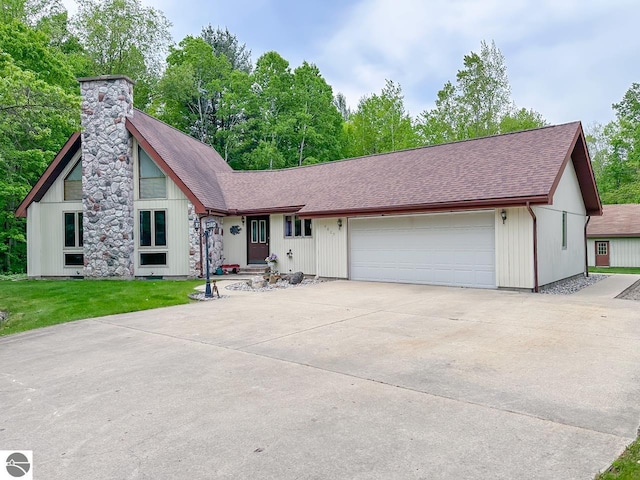 4809 N Alamando Rd, Coleman, MI 48618 - view of front of home with roof with shingles, a chimney, an attached garage, a front lawn, and driveway